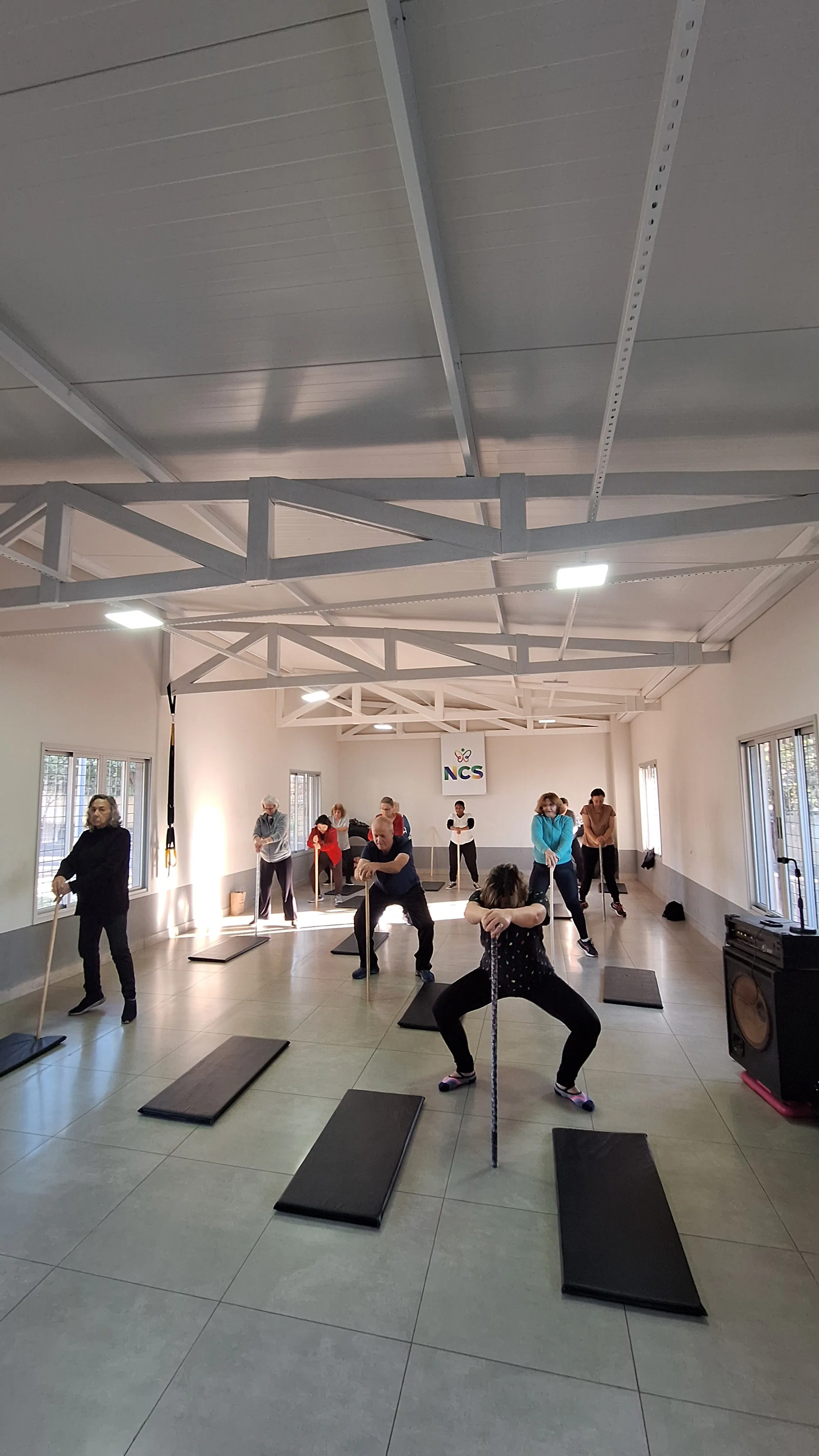 Grupo do Corpo em Equilíbrio reunido em pé no salão da NCS antes da aula.